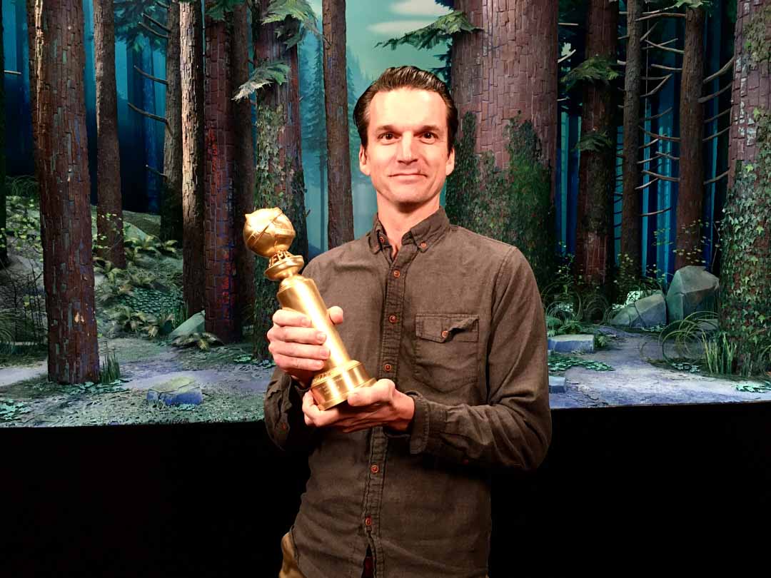 Micah Henrie holding the Golden Globe for Missing Link